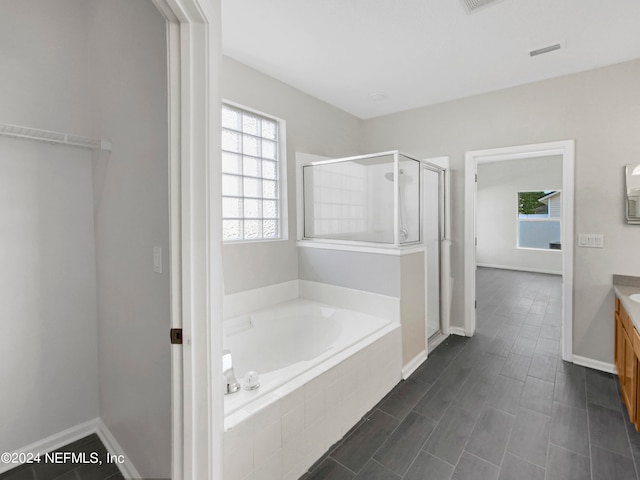 bathroom featuring vanity, independent shower and bath, and tile patterned floors