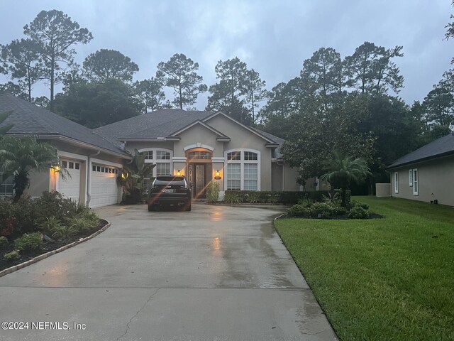 single story home featuring a front lawn and a garage