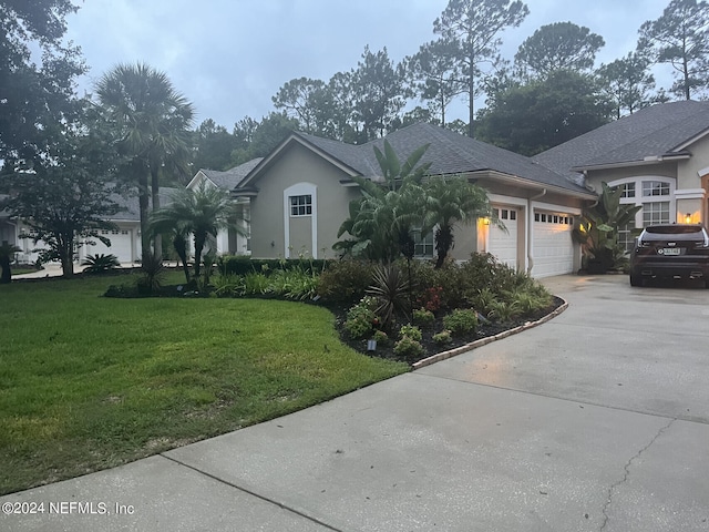 view of front of house with a garage and a front lawn