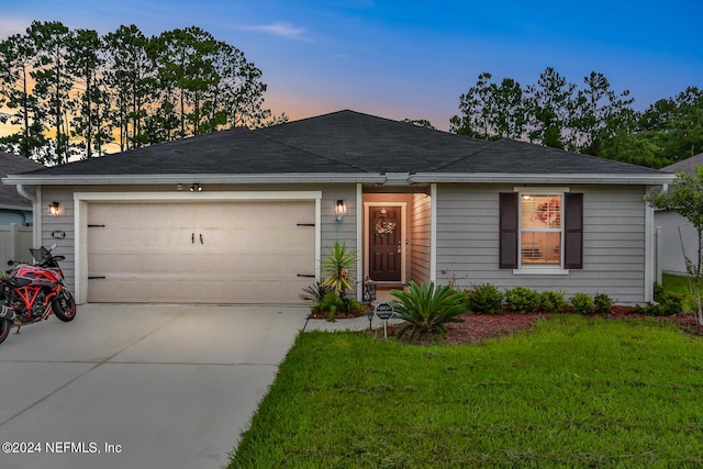 ranch-style home with a front yard, roof with shingles, driveway, and an attached garage