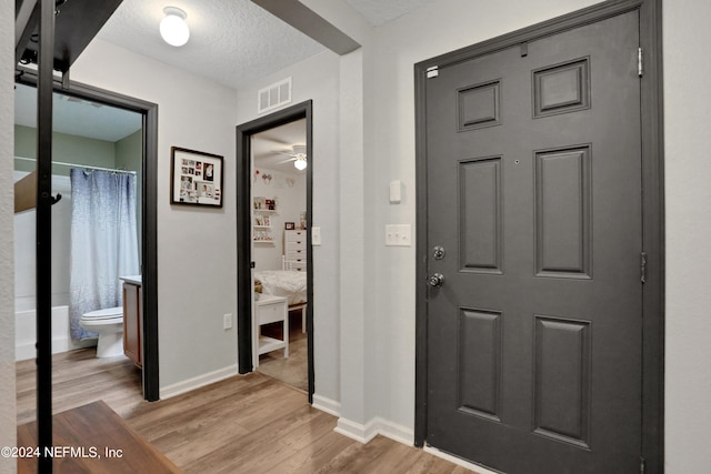 foyer featuring ceiling fan, a textured ceiling, and light hardwood / wood-style flooring