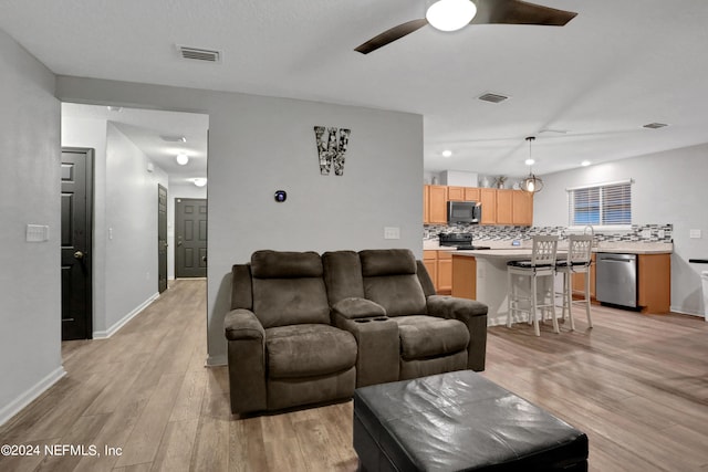 living room with ceiling fan and light wood-type flooring