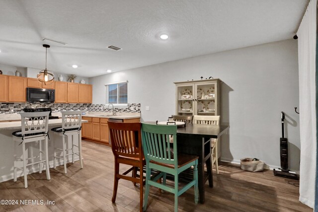 dining space featuring light hardwood / wood-style floors and sink