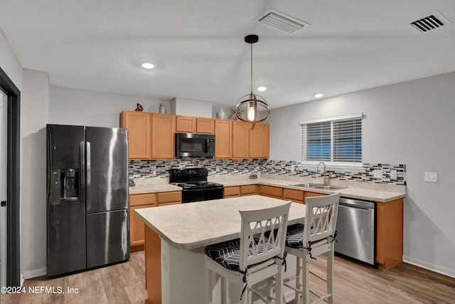 kitchen featuring black appliances, tasteful backsplash, light wood-type flooring, light brown cabinets, and sink