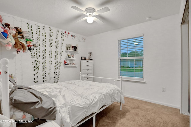 carpeted bedroom featuring a textured ceiling and ceiling fan