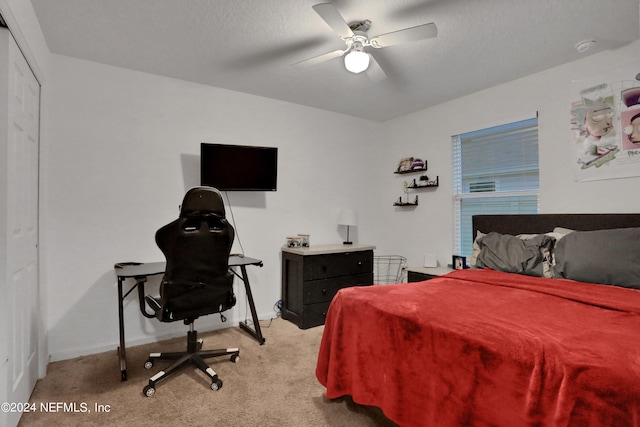 carpeted bedroom featuring ceiling fan and a closet