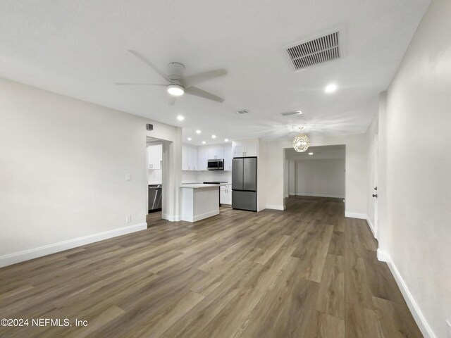 unfurnished living room with ceiling fan and wood-type flooring