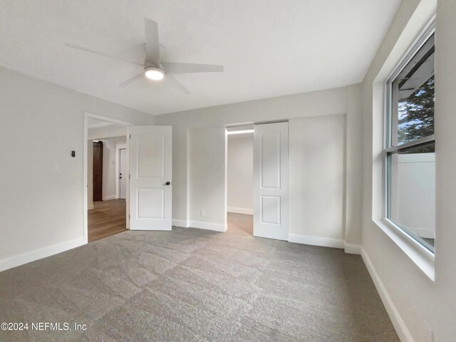 unfurnished bedroom with ceiling fan, carpet flooring, and a closet