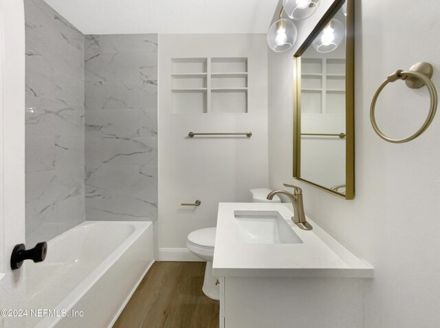 full bathroom with hardwood / wood-style flooring, tiled shower / bath combo, toilet, and vanity