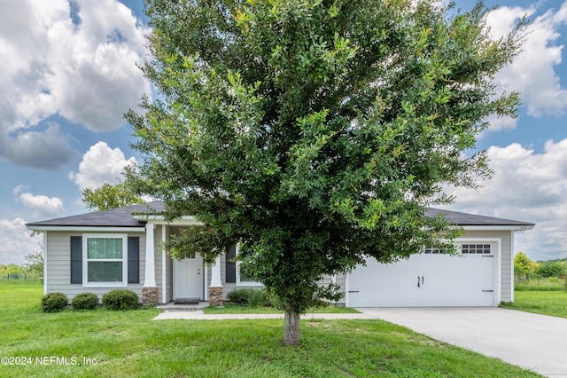 view of property hidden behind natural elements with a garage and a front yard