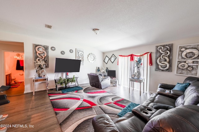 living room with wood-type flooring and a textured ceiling