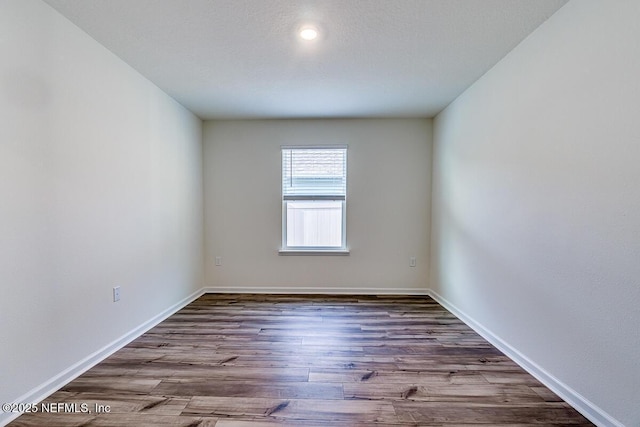 unfurnished room with dark wood-type flooring