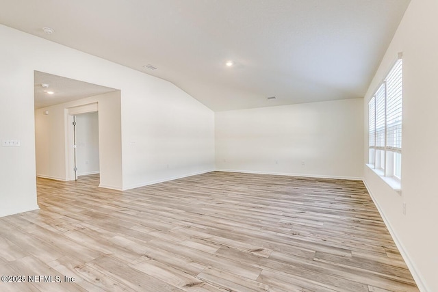 empty room with lofted ceiling and light hardwood / wood-style floors