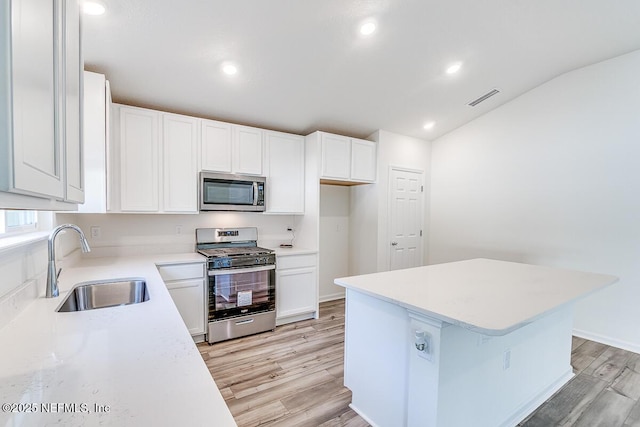 kitchen featuring white cabinetry, sink, stainless steel appliances, and a center island