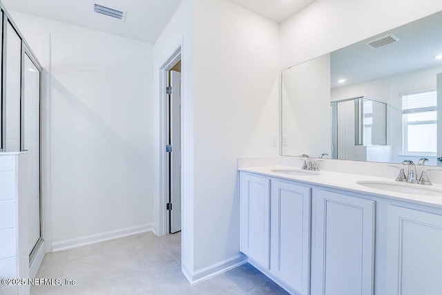 bathroom with a shower with shower door and vanity