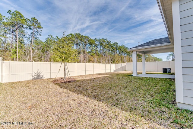 view of yard with central AC and a patio