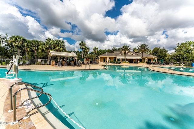 community pool featuring a patio and fence