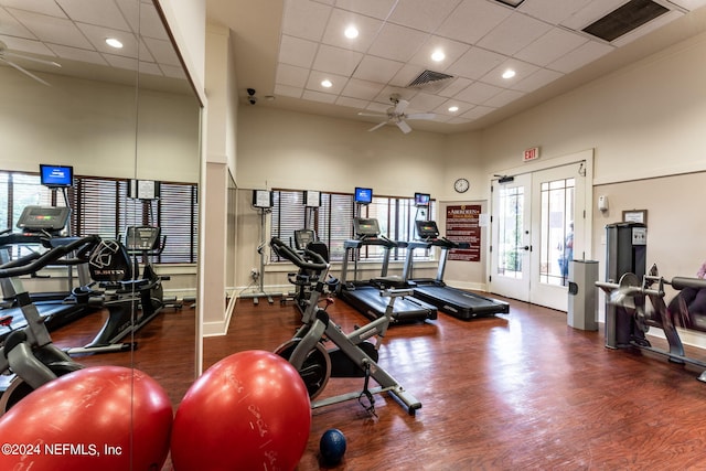 gym featuring visible vents, a towering ceiling, ceiling fan, wood finished floors, and french doors