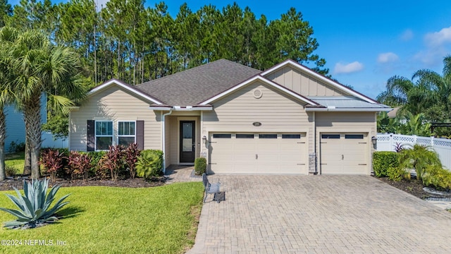 ranch-style house with decorative driveway, an attached garage, board and batten siding, fence, and a front lawn