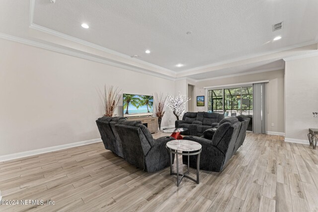 living room featuring a raised ceiling, light hardwood / wood-style floors, crown molding, and a textured ceiling