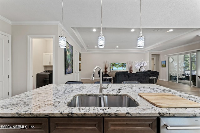 kitchen with light stone countertops, hardwood / wood-style flooring, crown molding, and sink