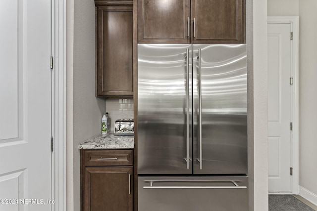 kitchen with dark brown cabinetry and high end refrigerator