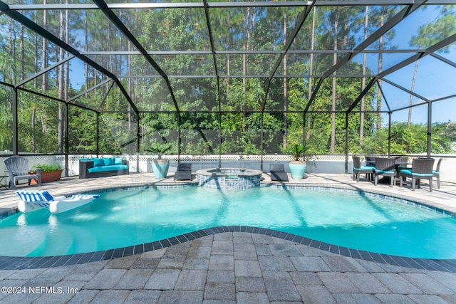 view of swimming pool featuring glass enclosure, a patio area, and an in ground hot tub