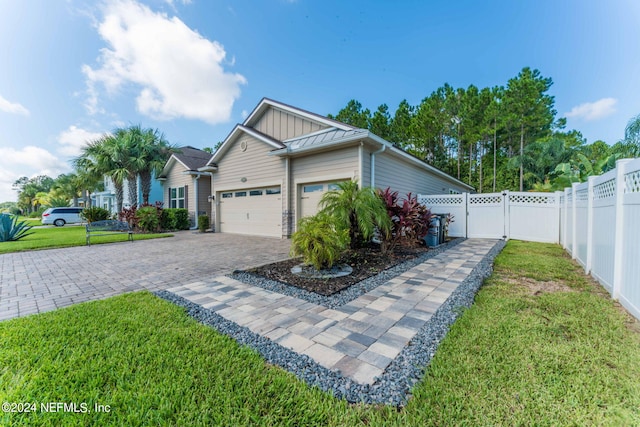 view of property exterior featuring decorative driveway, a lawn, board and batten siding, fence, and a garage