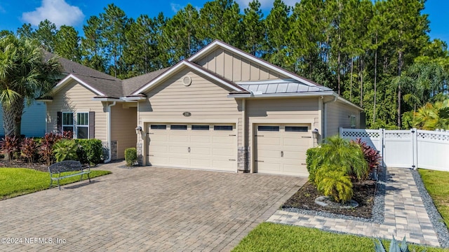 view of front of home featuring an attached garage, decorative driveway, fence, and board and batten siding