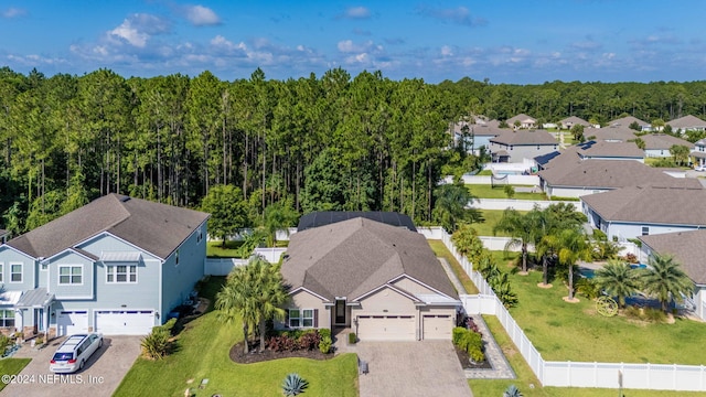 drone / aerial view featuring a residential view and a wooded view