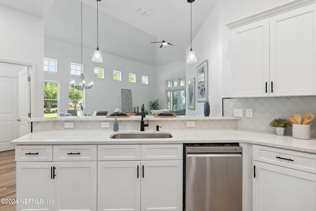 kitchen featuring light wood-type flooring, vaulted ceiling, dishwasher, decorative light fixtures, and sink