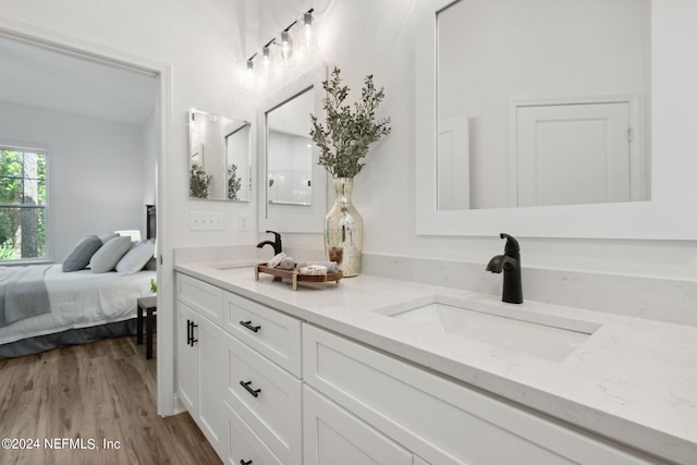 bathroom with dual vanity and wood-type flooring