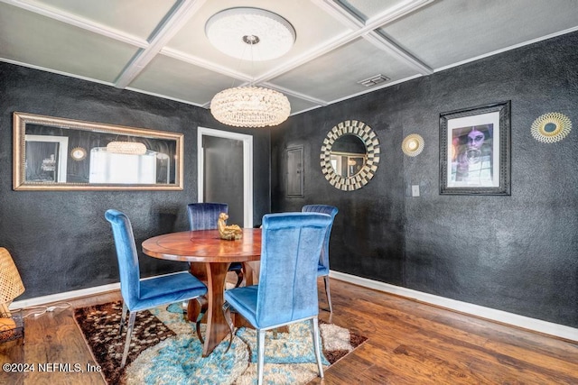 dining space featuring a notable chandelier, coffered ceiling, and hardwood / wood-style flooring