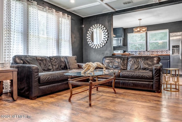 living room featuring hardwood / wood-style floors, coffered ceiling, and sink