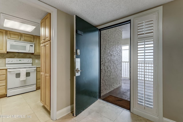 interior space with light tile patterned floors, light countertops, white appliances, and decorative backsplash