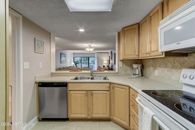 kitchen with white appliances, light tile patterned floors, decorative backsplash, light countertops, and a sink