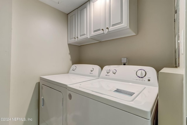 washroom featuring cabinet space and washing machine and clothes dryer