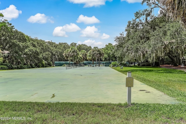 view of property's community with a lawn and fence