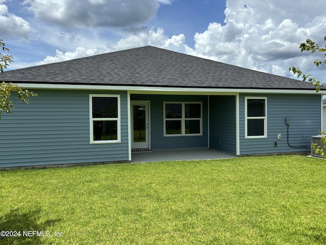 back of house with a patio and a lawn