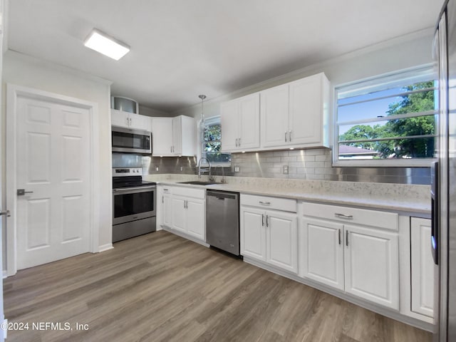 kitchen with white cabinetry, appliances with stainless steel finishes, light countertops, and a sink