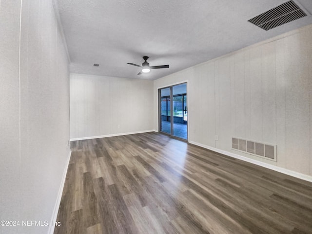 unfurnished room with dark wood-style floors, ceiling fan, and visible vents