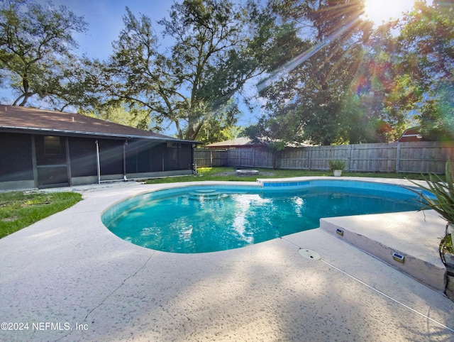 view of swimming pool with a fenced backyard, a sunroom, and a fenced in pool