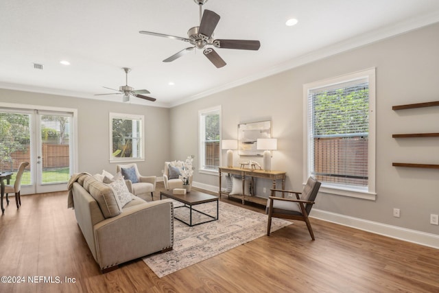 living room featuring hardwood / wood-style flooring, ceiling fan, and crown molding