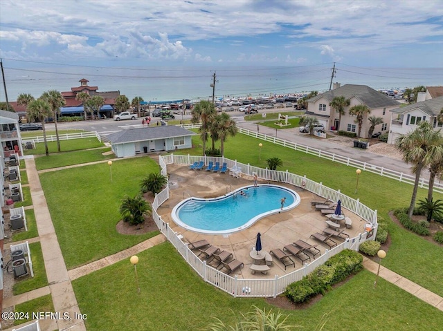 pool with a patio area, a fenced backyard, and a lawn