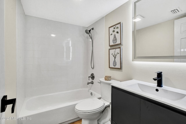 full bathroom featuring vanity, tiled shower / bath combo, and toilet