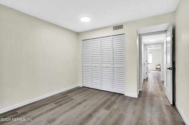 unfurnished bedroom featuring light hardwood / wood-style flooring and a closet