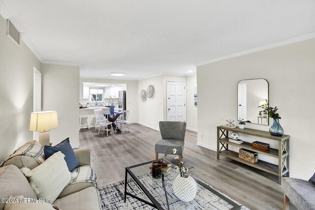 living room with crown molding and hardwood / wood-style floors