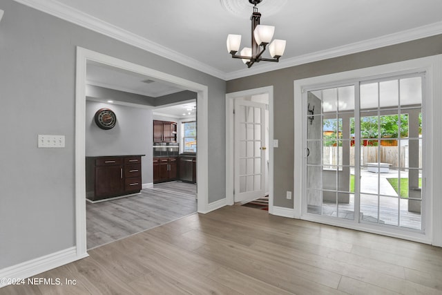 interior space featuring ornamental molding, a chandelier, and light hardwood / wood-style floors