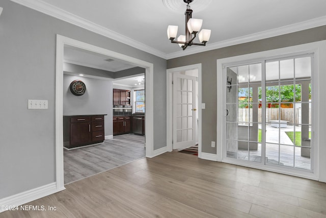 interior space with ornamental molding, a chandelier, and light wood-type flooring