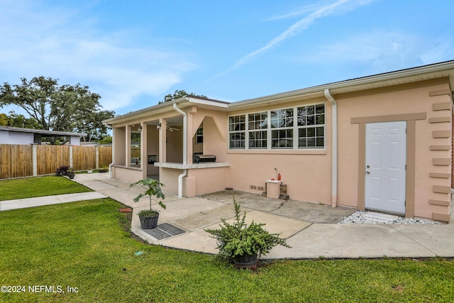 back of property with a patio, area for grilling, and a lawn